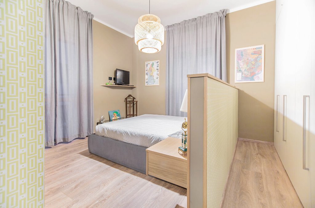 camera da letto con zona armadio posteriore al letto