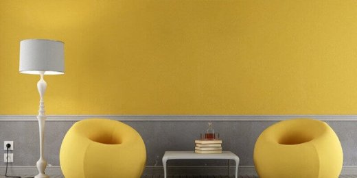 Parete giallo pantone con poltroncine puff gialle e lampada grigia