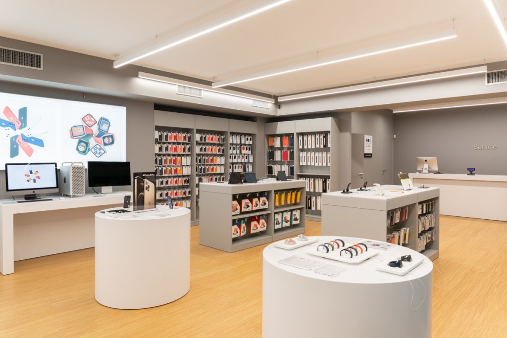 Store apple ristrutturato con pareti grigie e illuminazione a led. Esposizione Apple Watch