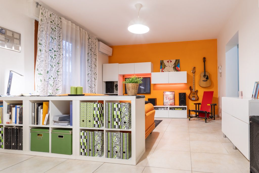 Soggiorno open space, mobili bianchi parete arancione Ristrutturazione divisione appartamento a Campi Bisenzio Firenze