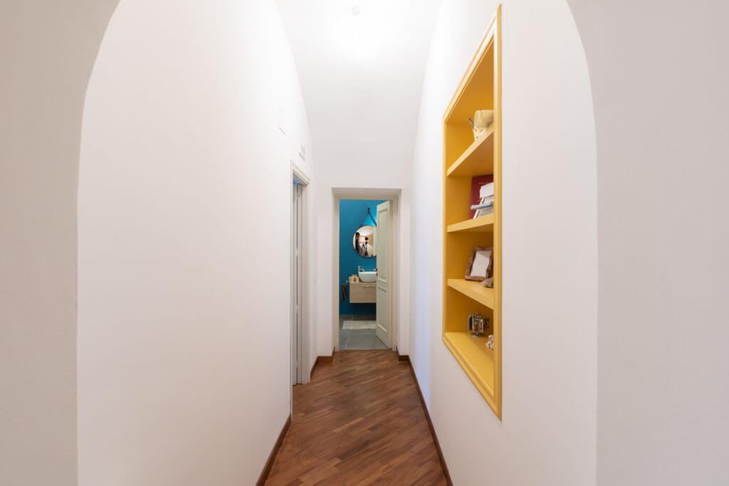 Corridoio con parquet e libreria su misura nel muro.