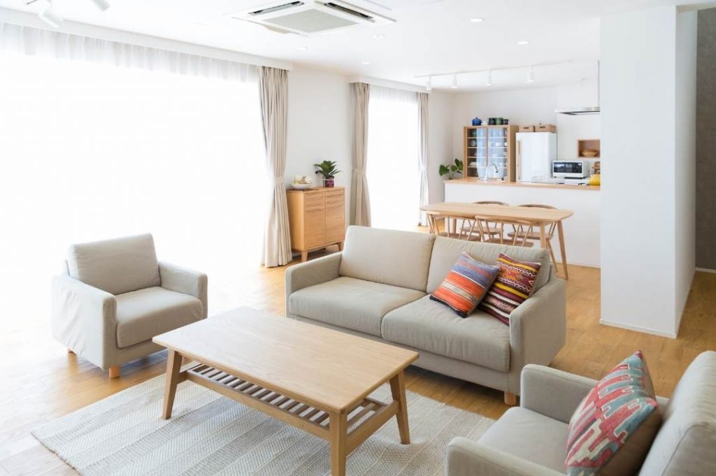 BONUS MOBILI 2021: tutte le novità per arredare casa! | Facile Ristrutturare Open space con divani e poltrone di colore grigio e tavolino basso in legno. Cucina con isola.