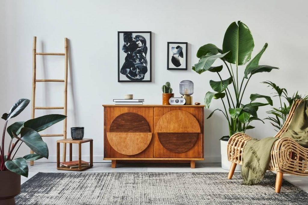 Stile Jungle per la casa vacanze di Paola Marella | Facile Ristrutturare arredo stile jungle per il soggiorno. Piante verdi, scala di legno e quadri bianco e nero.