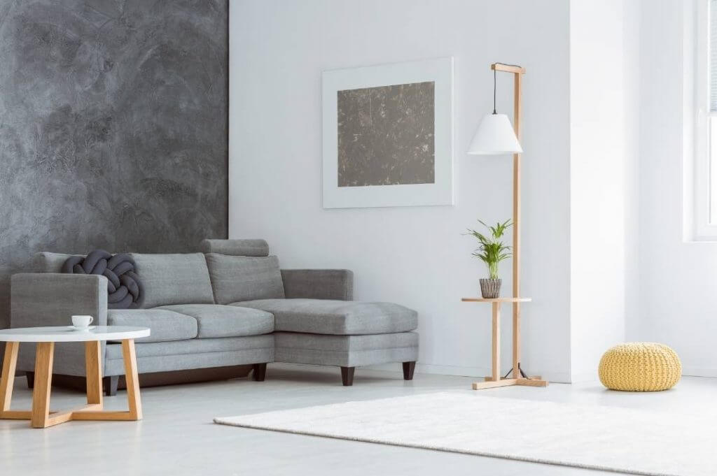 Arredare casa stile minimal: less is more! | Facile Ristrutturare Living room minimal con parete grigio scuro e divano angolare grigio.