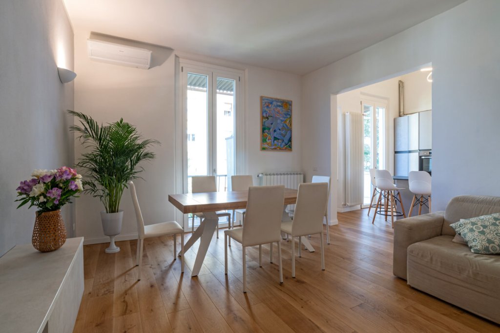 Open space con tavolo in legno e parquet.