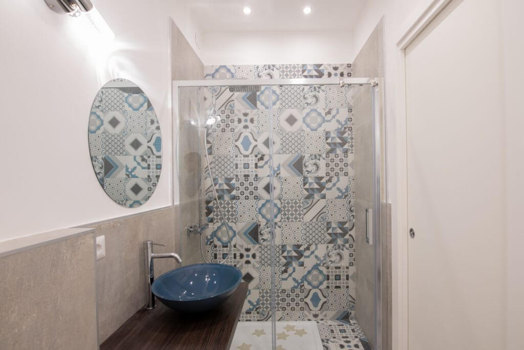 Bagno con box doccia con cementine e lavabo d'appoggio.