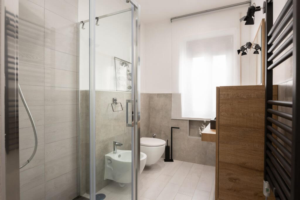Bagno moderno con piastrelle effetto legno ed effetto pietra.