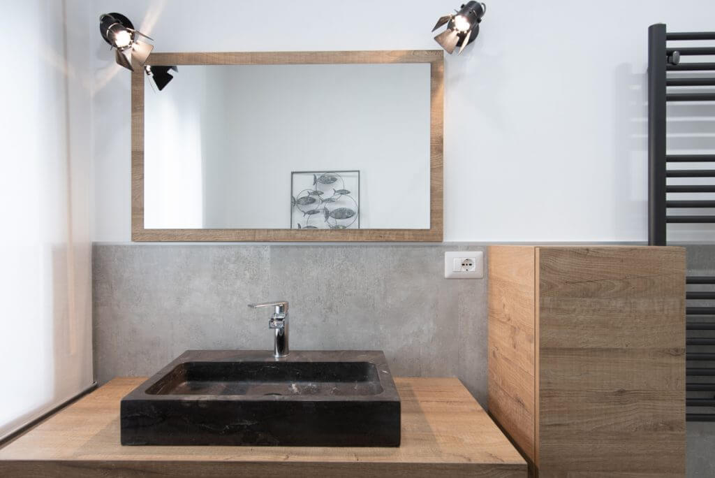 Bagno moderno con lavabo a sospensione nero.