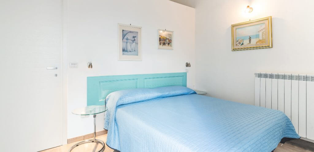 Progettare e ristrutturare un B&B grazie ai consigli dell’Arch. Vanin | Facile Ristrutturare Camerta con letto matrimoniale e testata azzurra.