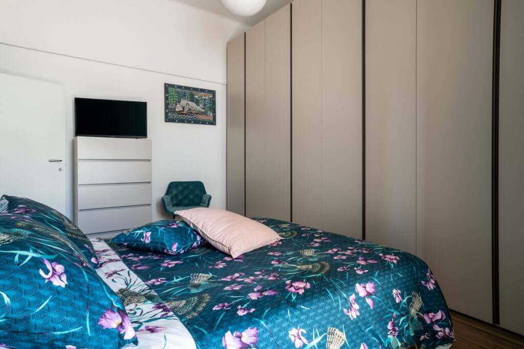 Camera da letto moderna con cassettiera e armadio a muro.