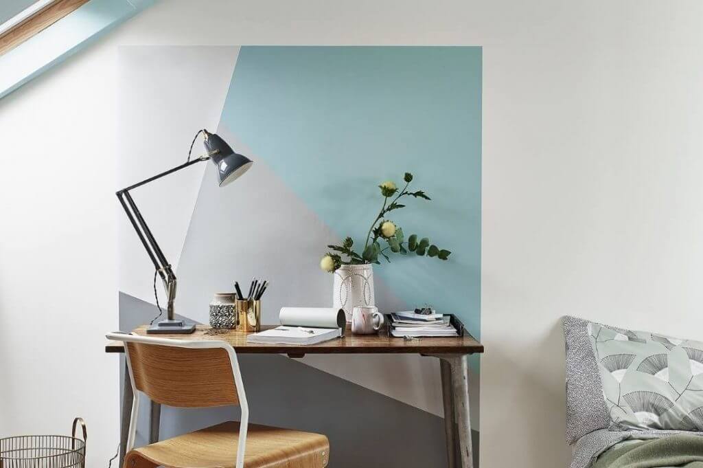 Come dividere gli ambienti con i colori di Sikkens | Facile Ristrutturare Angolo studio con lampada e parete dipinta con forme geometriche.
