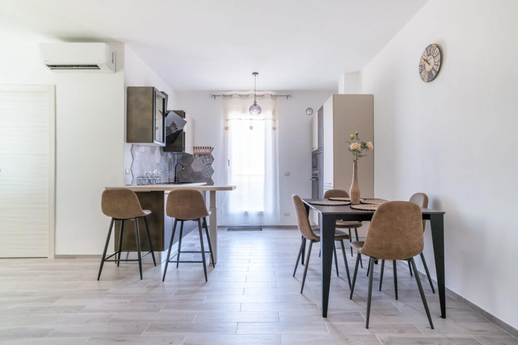 Open space moderno con cucina con penisola e mobili scuri.