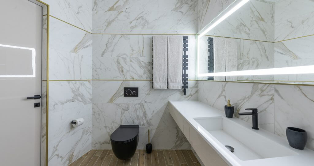 Cinque idee di ristrutturazione per il bagno piccolo | Facile Ristrutturare idee ristrutturazione bagno moderno con rivestimenti in marmo e sanitari bianchi e neri.