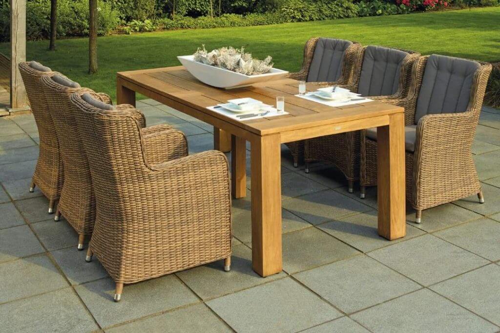 idee per ristrutturare casa di campagna: giardino con tavolo in legno e poltrone in rattan.