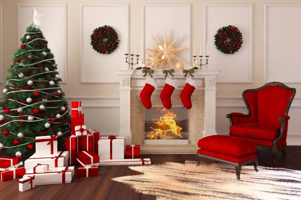 Natale is coming: come arredare casa in stile scandinavo | Facile Ristrutturare Arredare casa a Natale. Soggiorno con albero argento e rosso e pacchi regalo bianchi e rossi. Camino con calze della befana rosse.