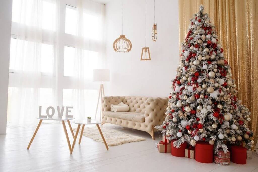 Natale is coming: come arredare casa in stile scandinavo | Facile Ristrutturare Arredare casa a Natale. Soggiorno con albero i natale argento e rosso accanto a un divano beige con tappeto peloso.