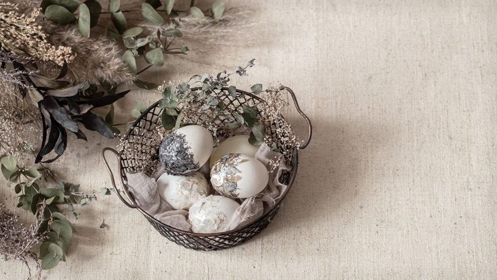 Uova di pasqua in cesto di vimini sul tavolo