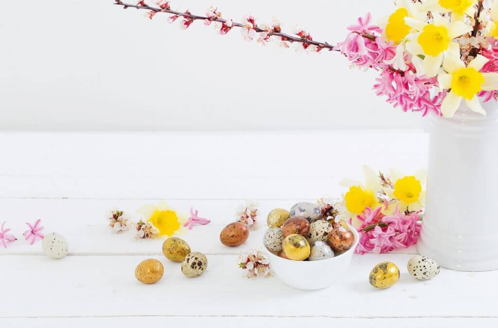 Tavola bianca con fiori e uova di cioccolato