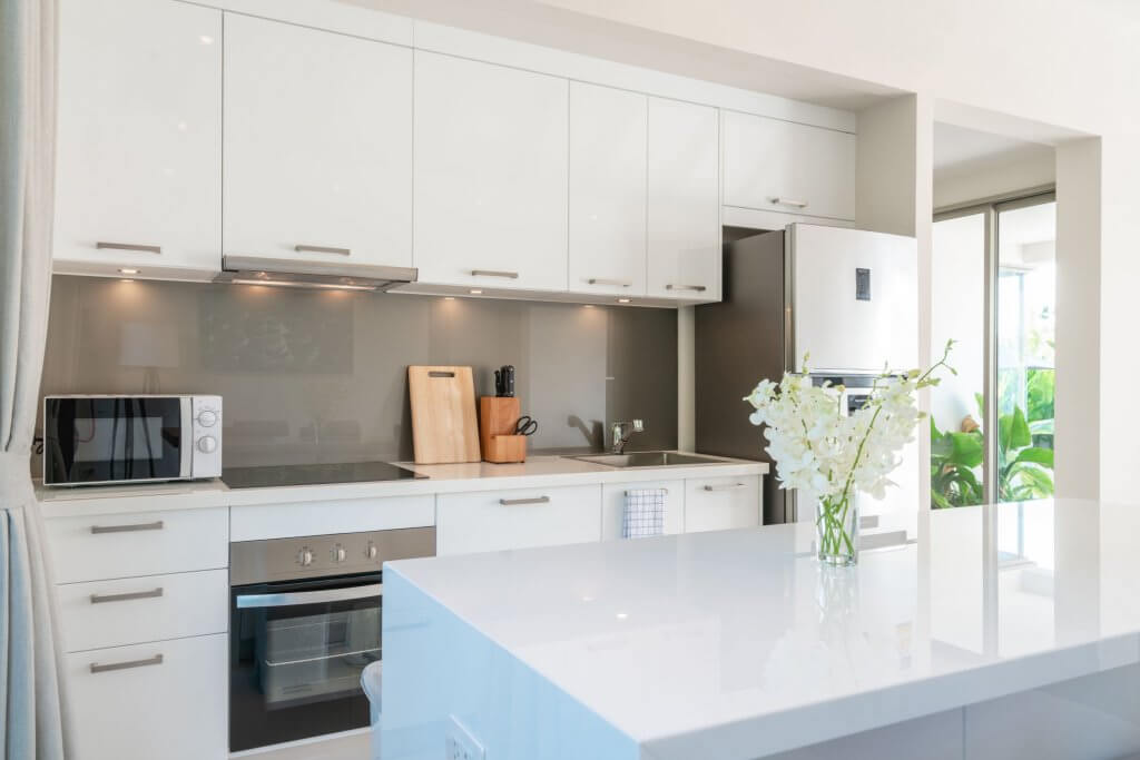Cucina senza piastrelle: consigli su come rivestire le pareti | Facile Ristrutturare Cucina bianca con paraschizzi grigio in vetro temperato