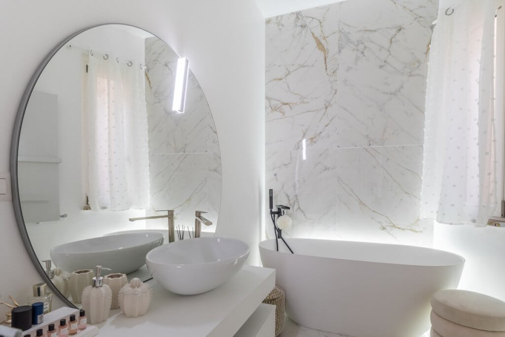 Progetto ristrutturazione Milano, bagno design, lavabo da appoggio, specchio rotondo, vasca da bagno