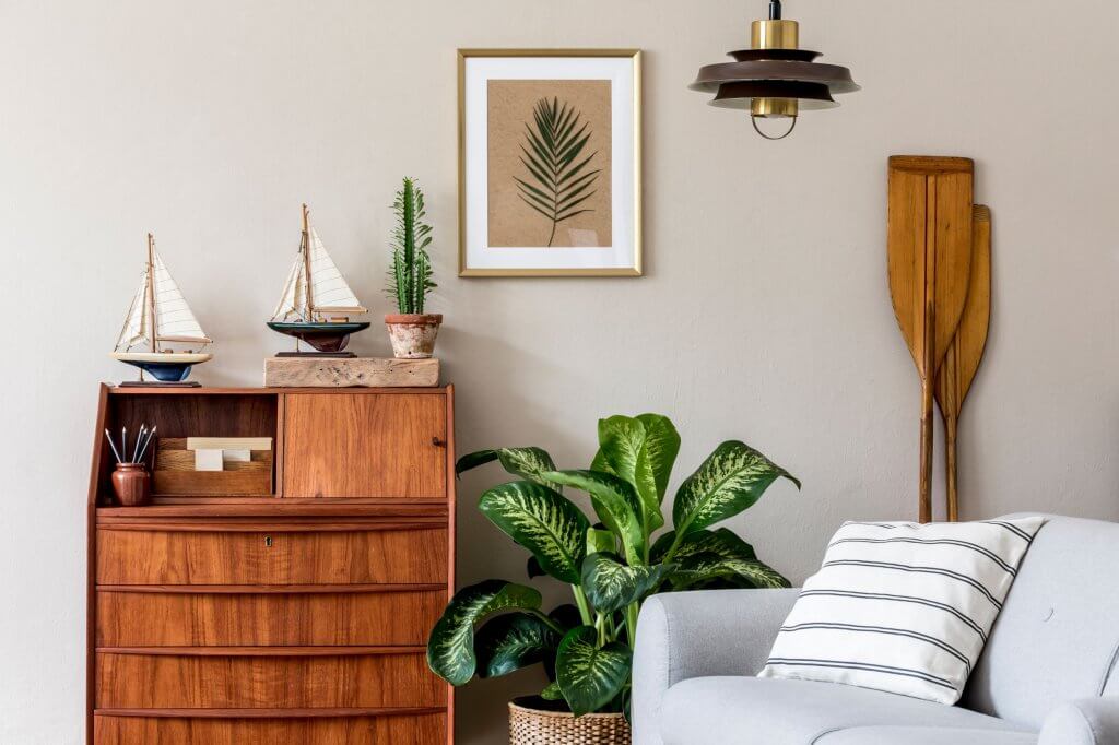 Coastal style, la nuova tendenza dell'interior design per portare il mare in casa | Facile Ristrutturare Soggiorno con arredamento in legno, quadro e pianta laterale in vaso