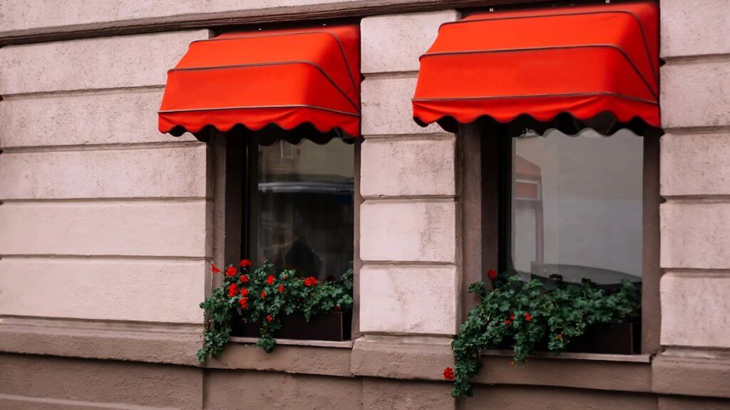 Bonus tende da sole 2022, detrazione del 50% | Facile Ristrutturare Tende da sole a cappottina di colore rosso con vasi e piante
