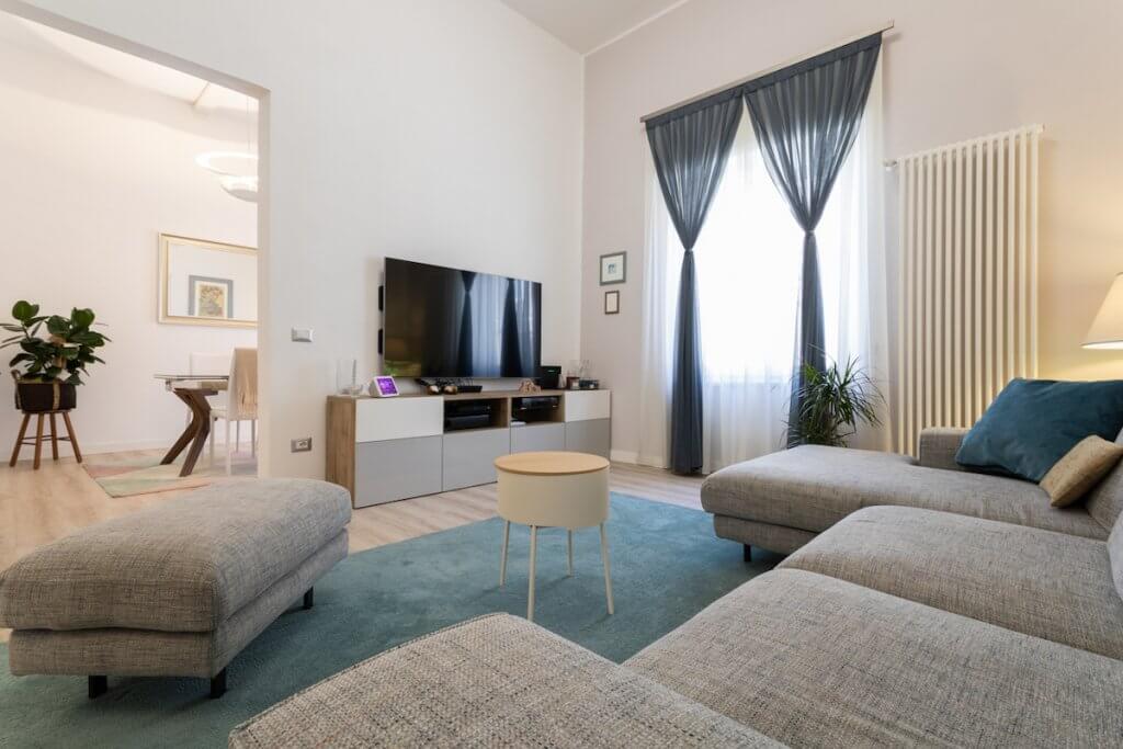 Ristrutturazione casa a Piombino, soggiorno living moderno con divano, tappeto, pouf, tavolino parete attrezzata, tv