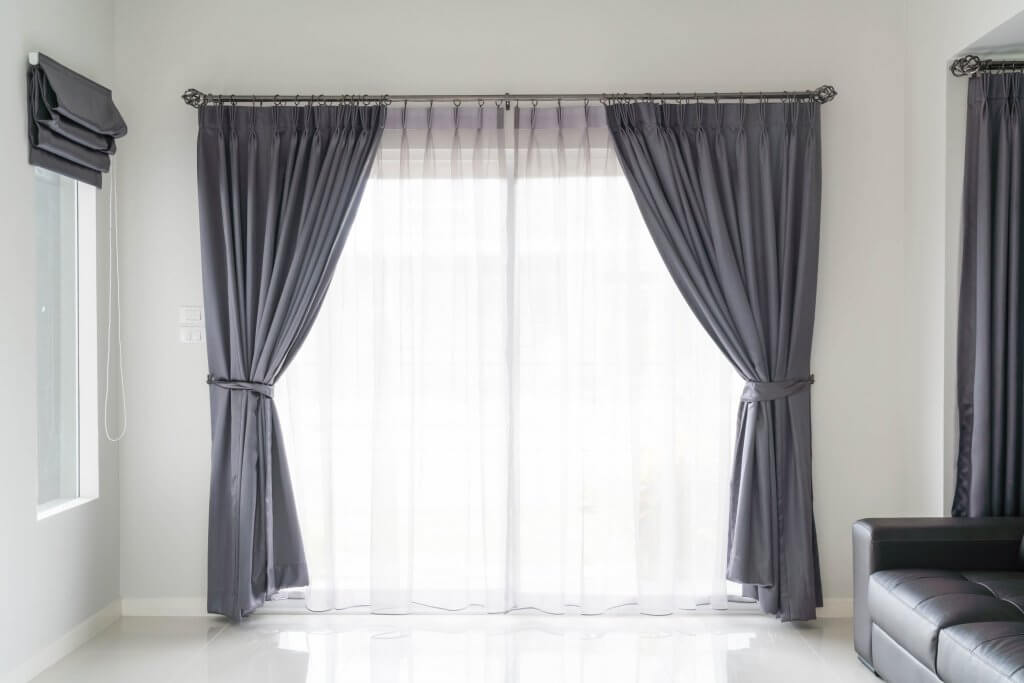 Tende per il living: la giusta scelta per l'estate | Facile Ristrutturare Soggiorno bianco con tende da sole, finestra laterale e divano in pelle nera