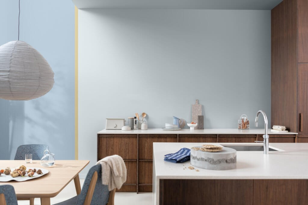 Wild Wonder: porta la magia della natura nella tua casa con la palette di Sikkens | Facile Ristrutturare Cucina con rivestimenti in legno, parete azzurra, top bianco e tavolo con sedia colore sikkens 2023 wild wonders