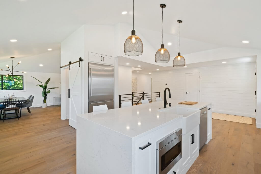 Ad ogni ambiente la sua illuminazione, scopri come arredare casa con la luce ideale | Facile Ristrutturare Cucina con lampadari sospesi dalle tonalità calde con rivestimenti bianchi e parquet