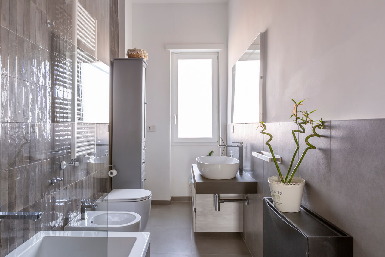 bagno dalle tonalità scure con rivestimenti in gres porcellanato