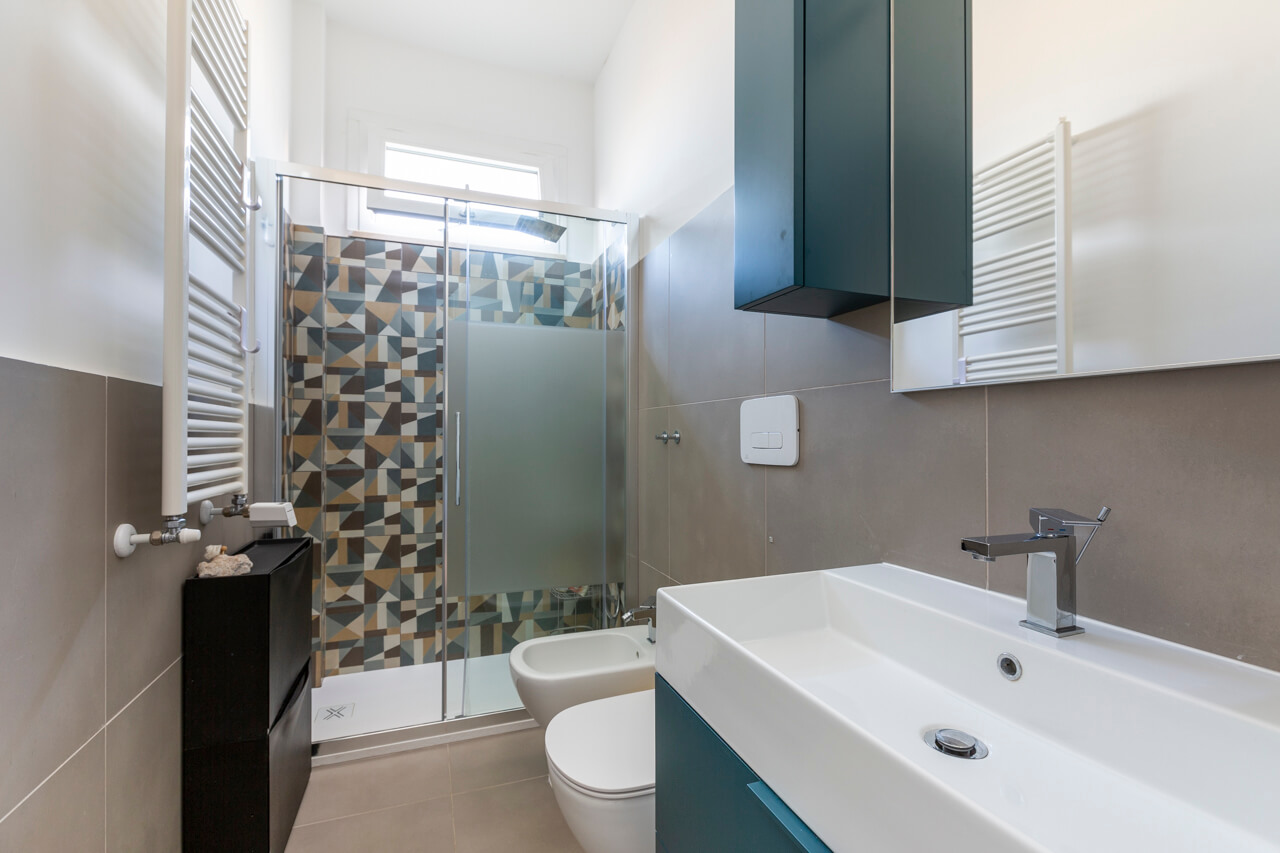 bagno dalle tonalità del blu con rivestimenti in gres porcellanato