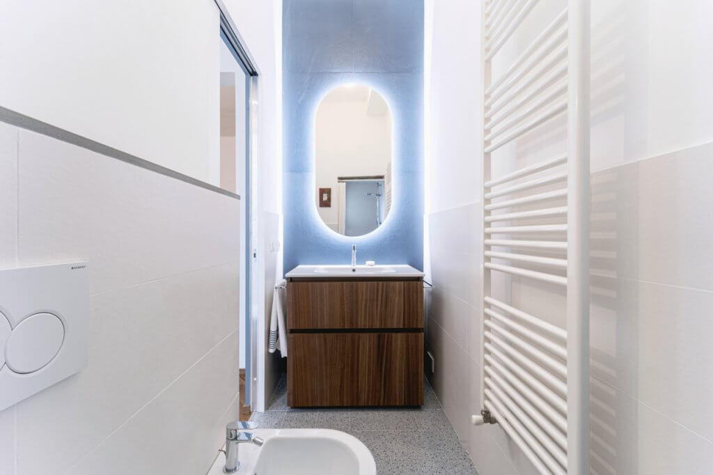 Bagno con pavimento in gres effetto graniglia e decori a parete