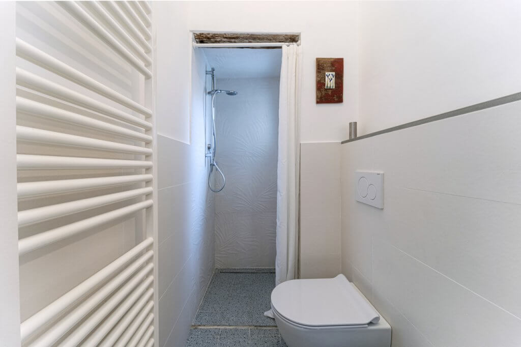 Bagno con pavimento in gres effetto graniglia