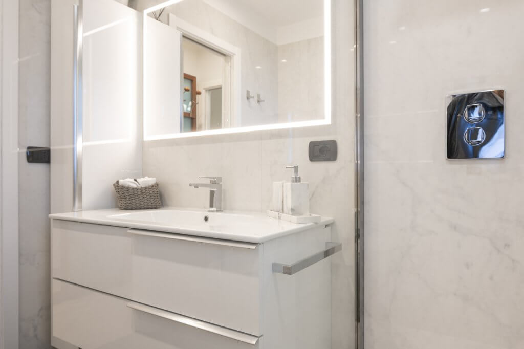 bagno dalle pareti rivestite con grandi lastre Calacatta