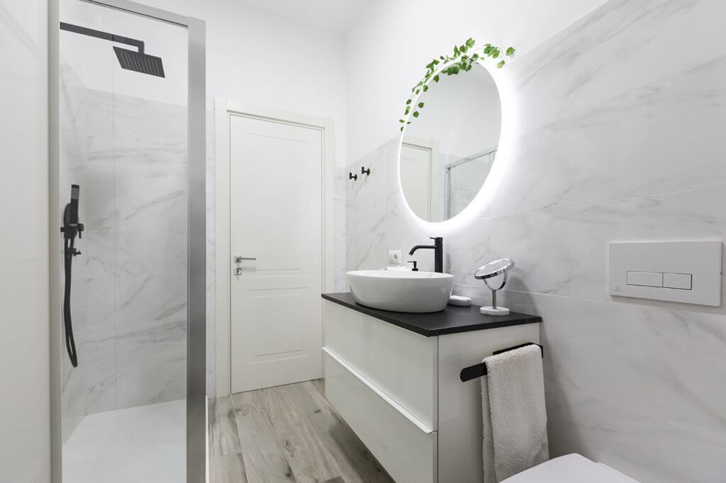 Bagno moderno con specchiera rotonda e lavabo di design