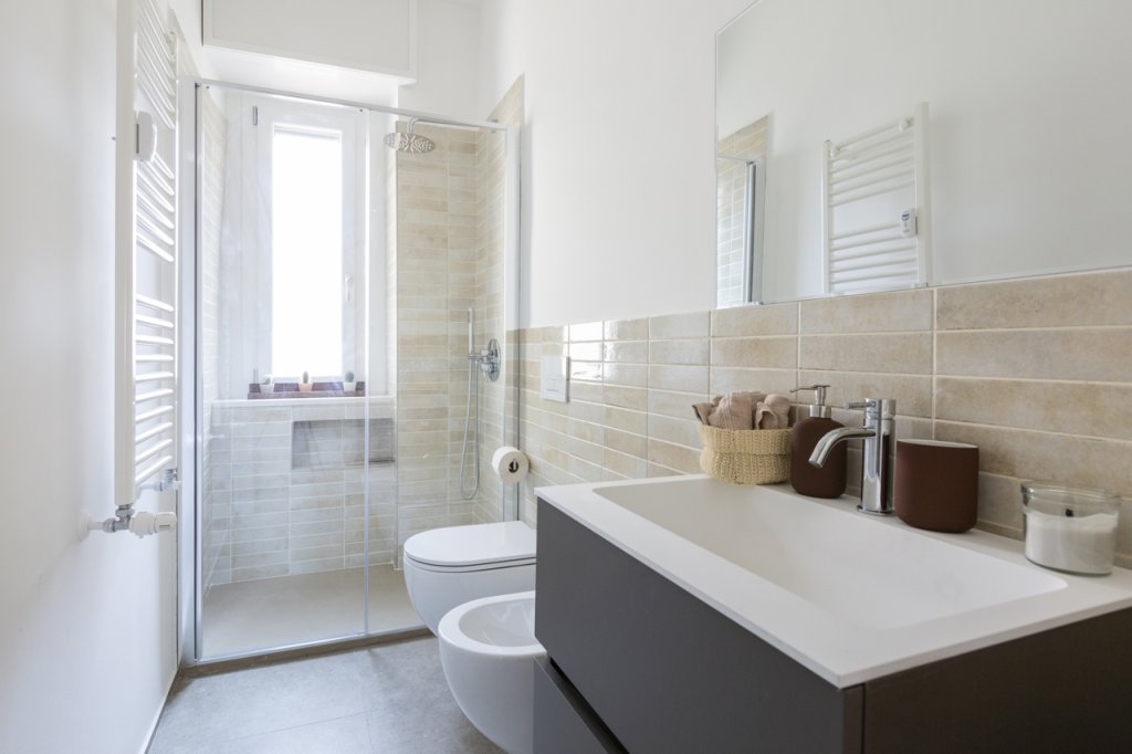 bagno con pavimento in gres e pareti bianche
