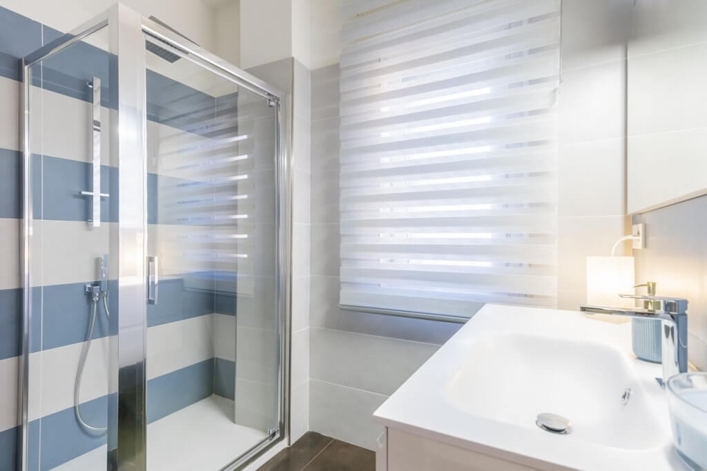 bagno con piastrelle bianche e azzurre