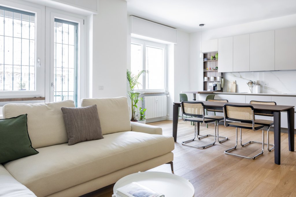 Open space moderno soggiorno cucina con parquet divano a elle