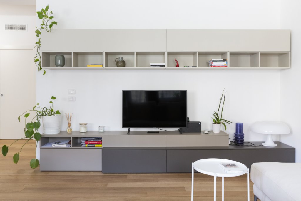 Soggiorno con parquet chiaro e parete attrezzata
