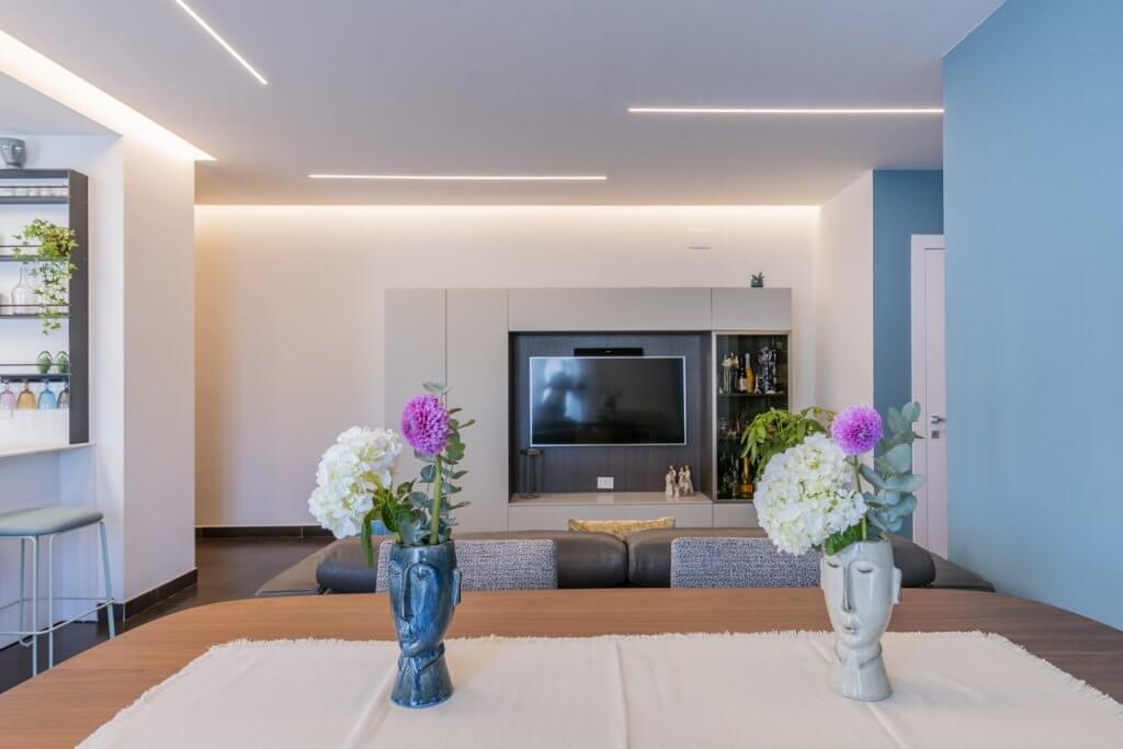 Open space con tavolo bianco e cucina moderna bianca
