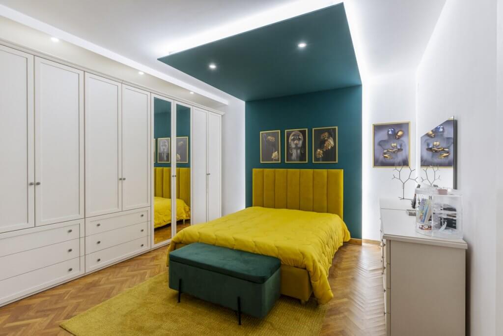 camera da letto con pareti bianche e verde petrolio